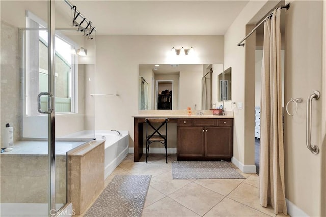 bathroom with vanity, a spacious closet, a shower stall, a bath, and tile patterned floors