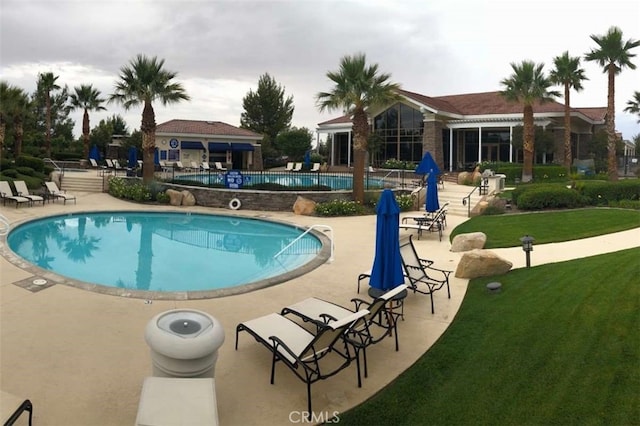 community pool featuring a patio area and a yard