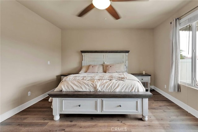 bedroom featuring a ceiling fan, baseboards, and wood finished floors