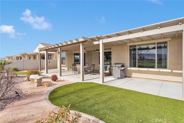 rear view of house with a pergola, a patio area, fence, and stucco siding