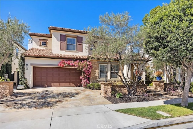 mediterranean / spanish-style home featuring a garage, concrete driveway, a tiled roof, and stucco siding