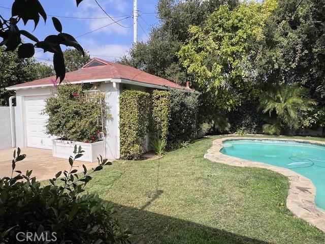 outdoor pool featuring a yard