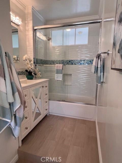 bathroom with enclosed tub / shower combo, wood finished floors, crown molding, and vanity