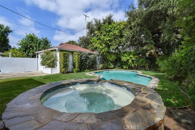 view of swimming pool with a pool with connected hot tub, fence, and a yard