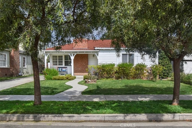 view of front of home featuring brick siding, a porch, and a front yard