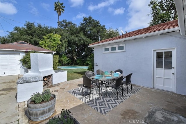 view of patio / terrace with exterior fireplace, an outdoor pool, and outdoor dining space