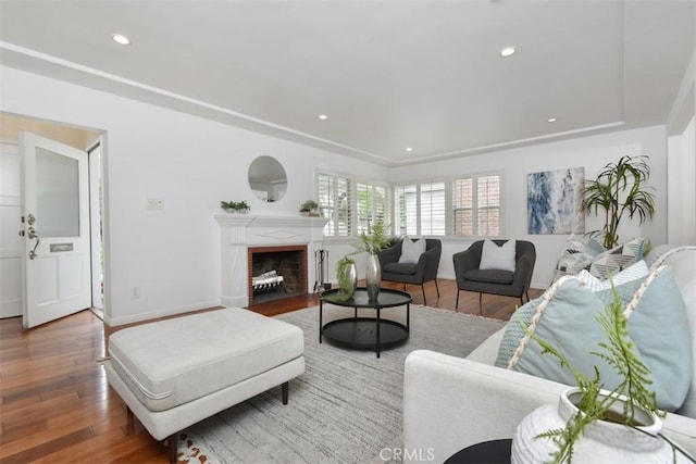 living room with recessed lighting, wood-type flooring, a fireplace, and baseboards