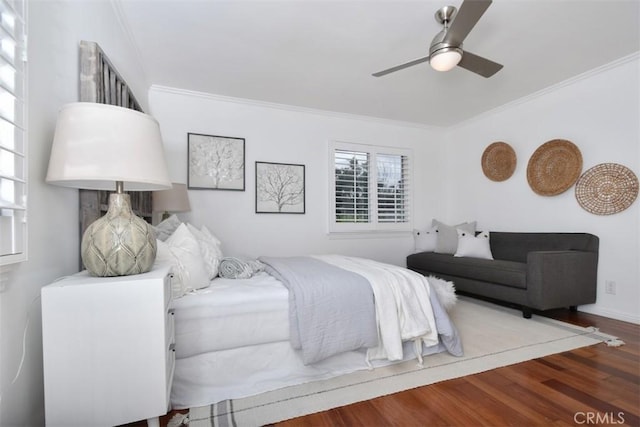 bedroom with ornamental molding, wood finished floors, a ceiling fan, and baseboards