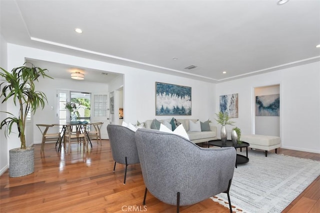 living area with baseboards, light wood-style flooring, and recessed lighting