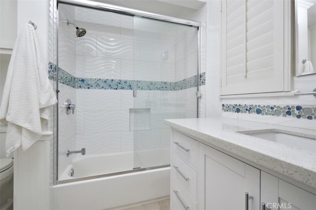 full bath with toilet, shower / bath combination with glass door, tasteful backsplash, and vanity