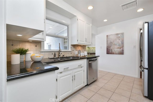 kitchen with a sink, visible vents, white cabinetry, appliances with stainless steel finishes, and decorative backsplash