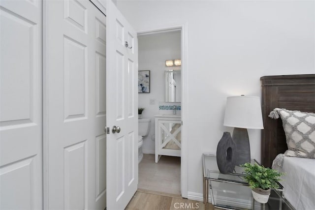 bedroom with wood finished floors and baseboards