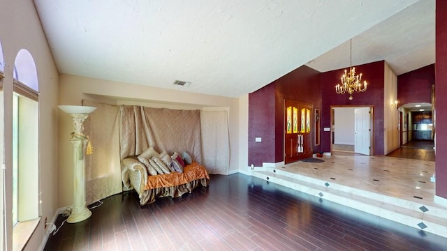 unfurnished room with high vaulted ceiling, visible vents, wood finished floors, a chandelier, and baseboards