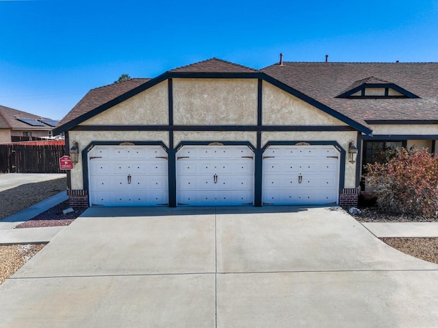 view of front of home featuring a garage, fence, concrete driveway, and stucco siding