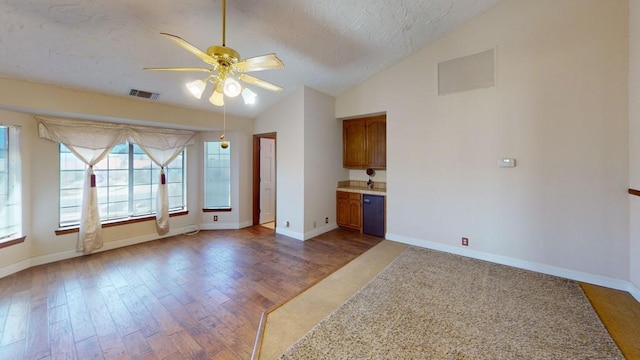 spare room with lofted ceiling, a textured ceiling, visible vents, and wood finished floors