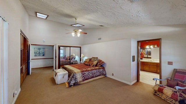 bedroom with a textured ceiling, light colored carpet, visible vents, baseboards, and vaulted ceiling