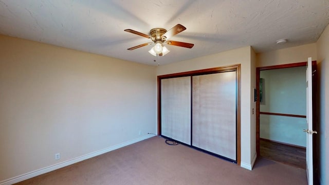 unfurnished bedroom featuring carpet floors, a ceiling fan, baseboards, and a closet