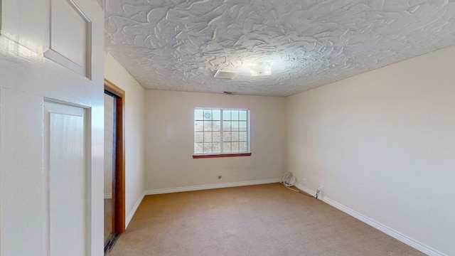 unfurnished room with light carpet, a textured ceiling, and baseboards