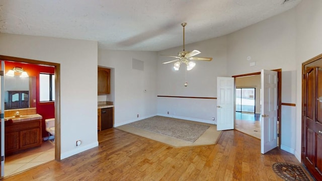 unfurnished room featuring baseboards, visible vents, ceiling fan, light wood-style floors, and a sink