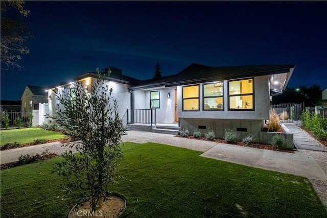 view of front of house with a yard, crawl space, and fence