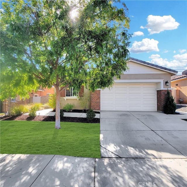 view of front of home with a garage, brick siding, driveway, and a front lawn