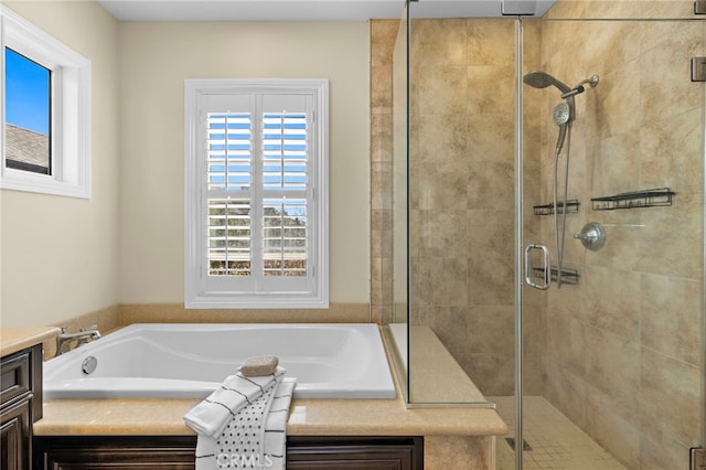 full bathroom featuring a bath, a shower stall, and vanity