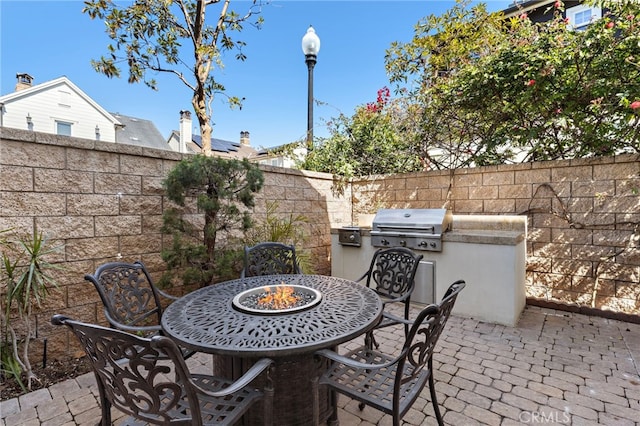 view of patio / terrace featuring outdoor dining area, an outdoor kitchen, area for grilling, and a fenced backyard