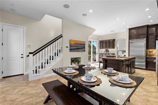 dining area featuring light tile patterned floors, stairway, arched walkways, and recessed lighting