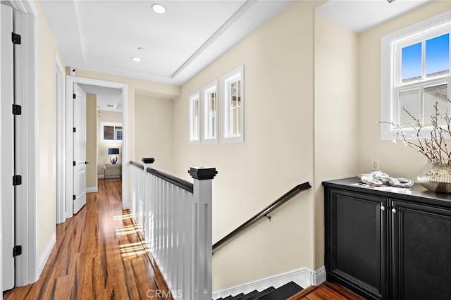 corridor with recessed lighting, baseboards, an upstairs landing, and wood finished floors