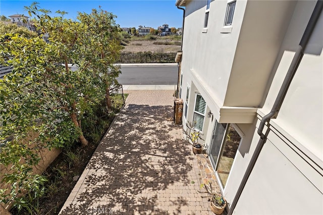 view of side of property featuring stucco siding and fence