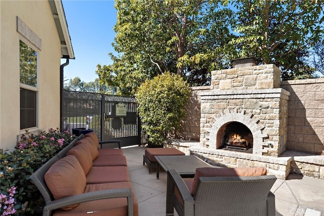 view of patio / terrace with an outdoor living space with a fireplace and fence