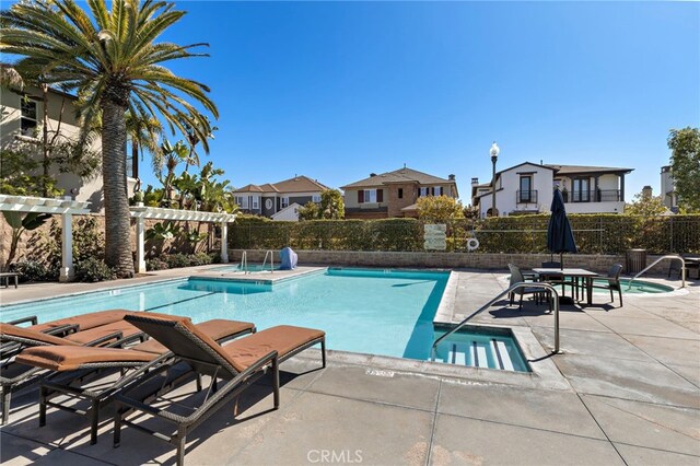 pool with a patio, fence, a pergola, and a residential view