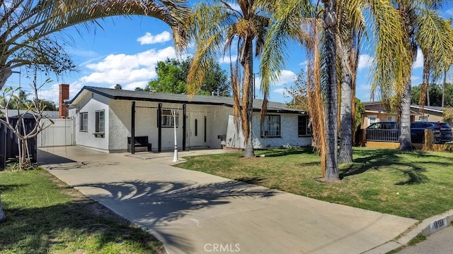 view of front of property featuring driveway, a front yard, fence, and stucco siding