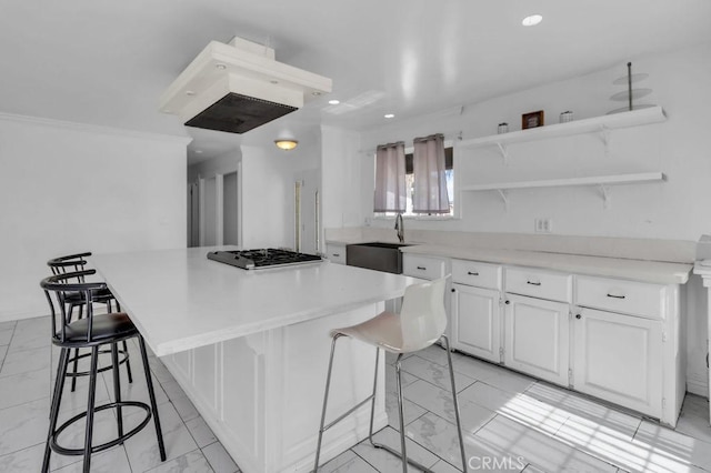 kitchen featuring marble finish floor, stainless steel gas cooktop, open shelves, and a sink