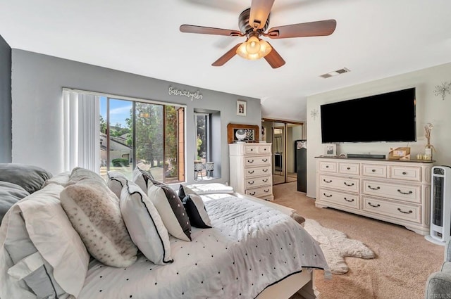 bedroom featuring a ceiling fan, visible vents, a closet, and light colored carpet