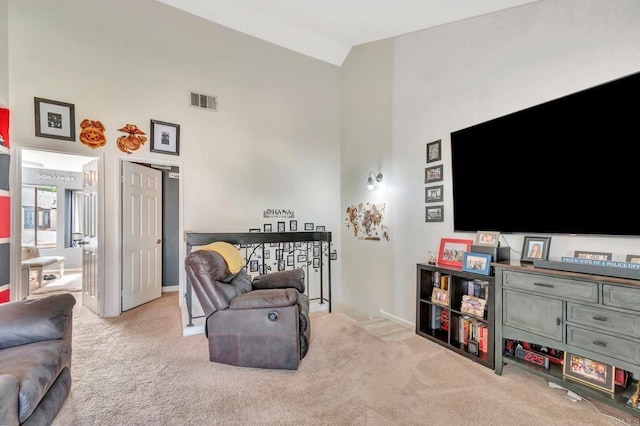 carpeted living room with visible vents, high vaulted ceiling, and baseboards