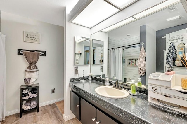 bathroom with a skylight, curtained shower, visible vents, vanity, and wood finished floors