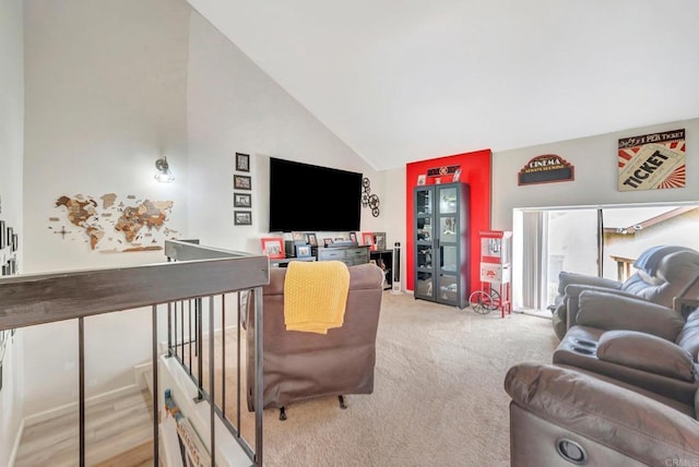 living area with high vaulted ceiling and light colored carpet