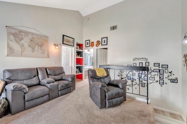 living room with high vaulted ceiling and visible vents