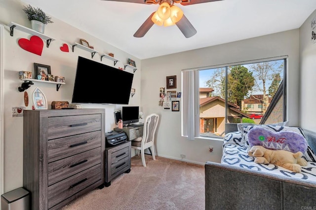 office space featuring light carpet, baseboards, and a ceiling fan