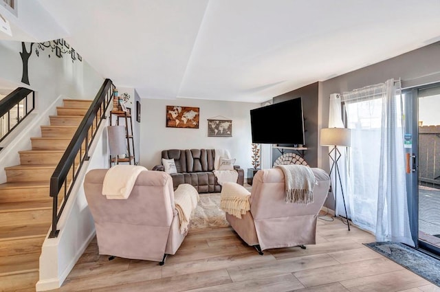 living area with stairs and light wood finished floors