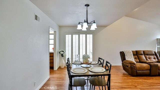 dining area featuring visible vents, baseboards, an inviting chandelier, and wood finished floors