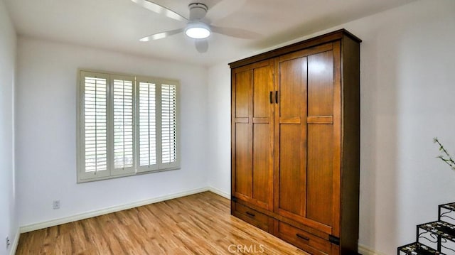 unfurnished bedroom featuring baseboards, light wood-style floors, and a ceiling fan