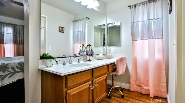 bathroom with vanity, wood finished floors, and baseboards