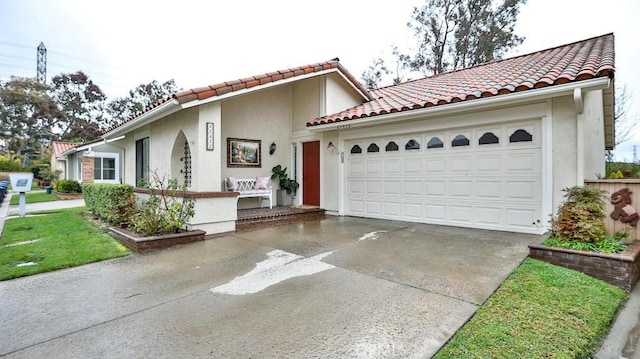 mediterranean / spanish-style home featuring stucco siding, concrete driveway, an attached garage, and a tile roof