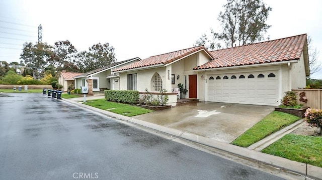 mediterranean / spanish-style home with stucco siding, an attached garage, a tile roof, and driveway