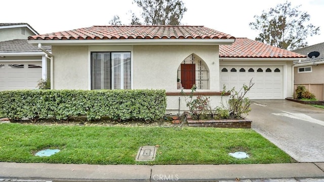 mediterranean / spanish-style home with stucco siding, concrete driveway, an attached garage, and a tile roof