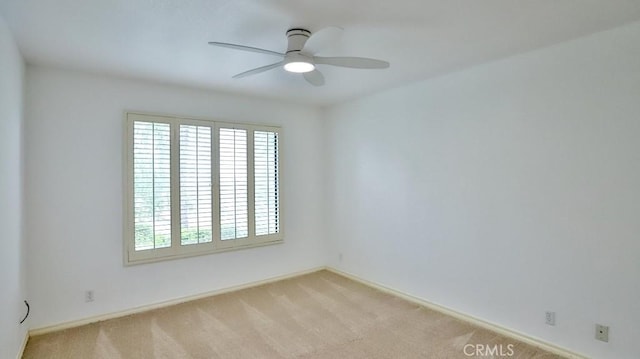 unfurnished room featuring light carpet and a ceiling fan