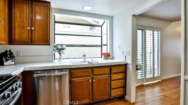 kitchen featuring brown cabinetry, appliances with stainless steel finishes, and a sink