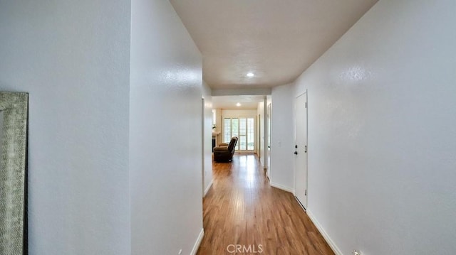 hallway with wood finished floors and baseboards